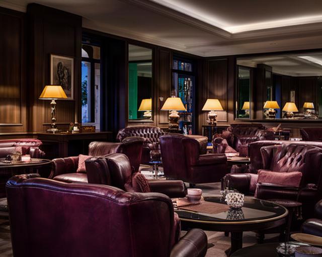 Lounge riservata del club maschile a Trinitapoli con poltrone in pelle e illuminazione calda serale